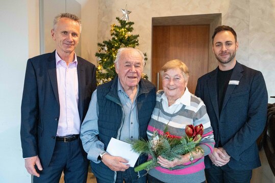Ehepaar wird als langjährige Mieter bei der wbg geehrt und bekommen Blumen und ein Geschenk überreicht.