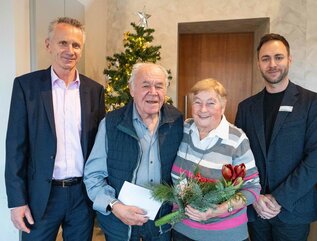 Ehepaar wird als langjährige Mieter bei der wbg geehrt und bekommen Blumen und ein Geschenk überreicht.