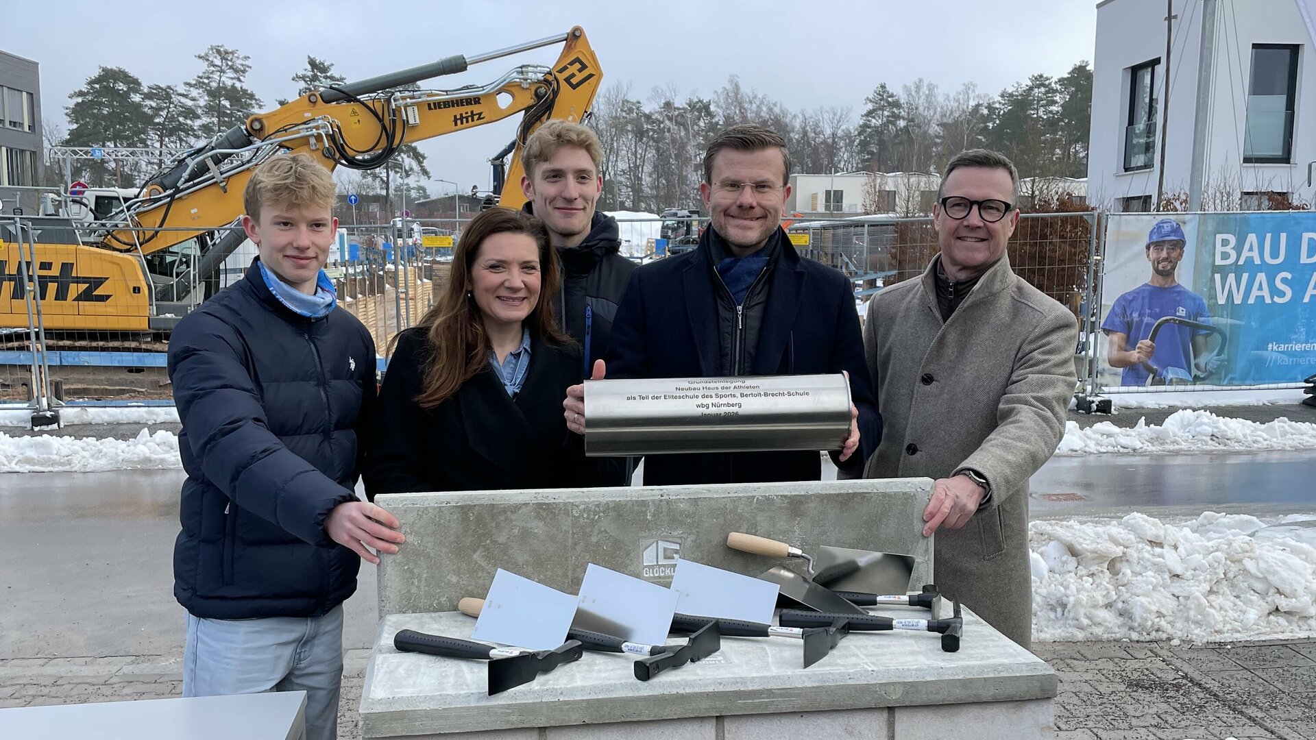 Vier Personen stehen hinter dem symbolischen Grundstein.