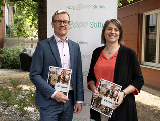 Bildmotiv: wbg-Geschäftsführer und Vorsitzender des Stiftungsvorstandes Ralf Schekira mit Sozialreferentin und der Vorsitzenden des Stiftungsbeirats Elisabeth Ries zeigen die Jubiläumsschrift. Foto: Meike Schulig, wbg Nürnberg